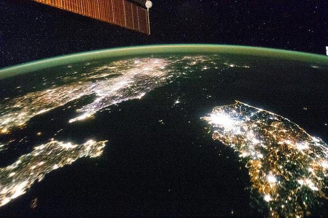 Photo taken from a satellite at night showing the lights of South Korea (bottom right) and China (left half). The black space in between is the isolated country of North Korea.