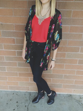 Junior Trinity Swift is wearing high-waisted jeans, booties, a bright flowy tank top, floral kimono, and a bold necklace. All of these pieces form a lively spring outfit. 