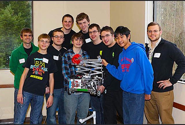 Last year's Robotics Club poses as they hold up one of their creations.