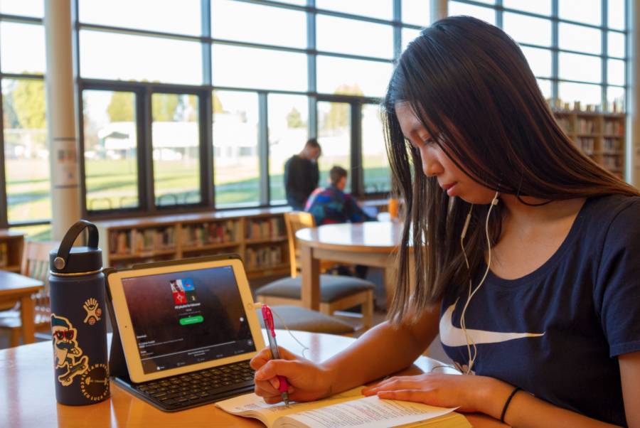 Junior Julia Tran listens to her Spotify playlist while working on homework in the library.