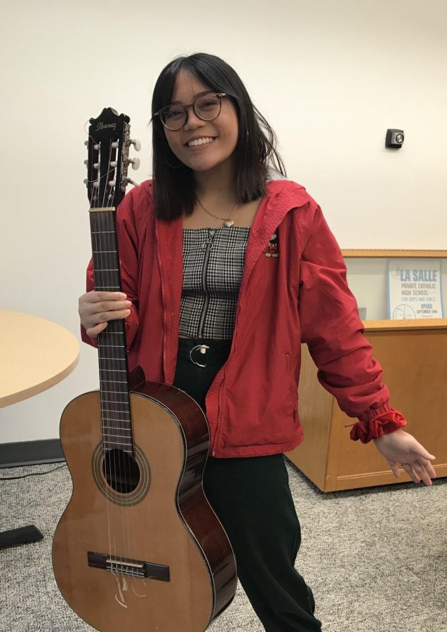 Junior Alison Paguio holding one of her favorite instruments to write songs with, her guitar.
