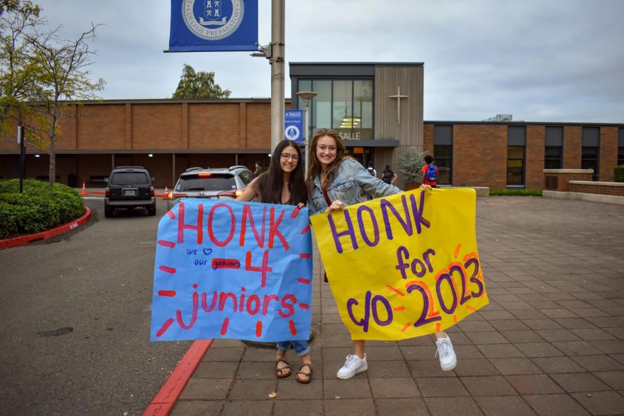 Seniors Maria George and Camille Brumbaugh welcome students on the first day of school.