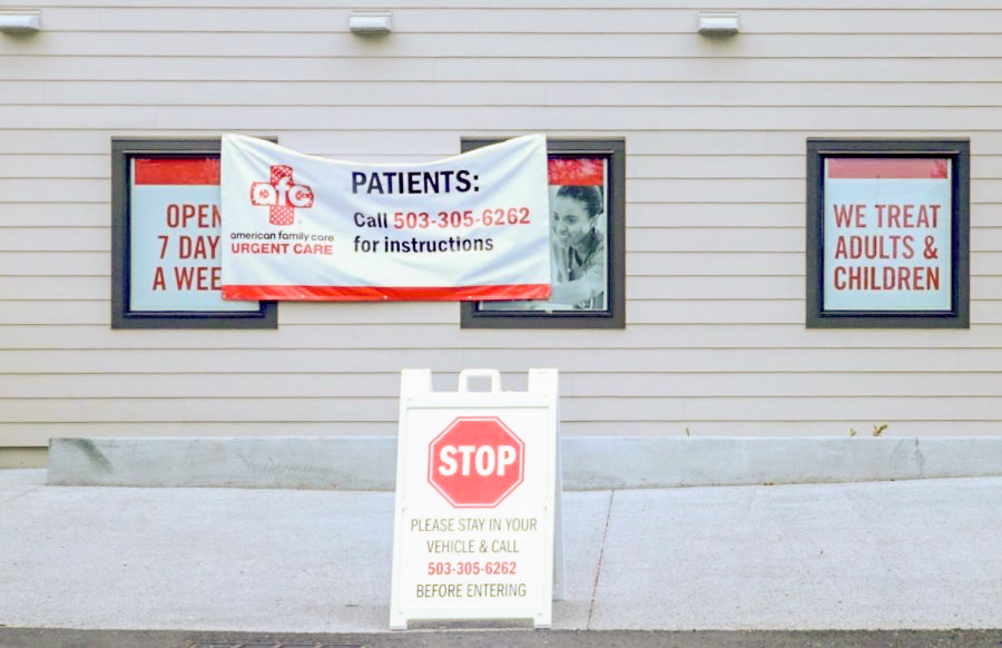An urgent care center in Oregon City displays signs warning visitors to take necessary social distancing precautions.