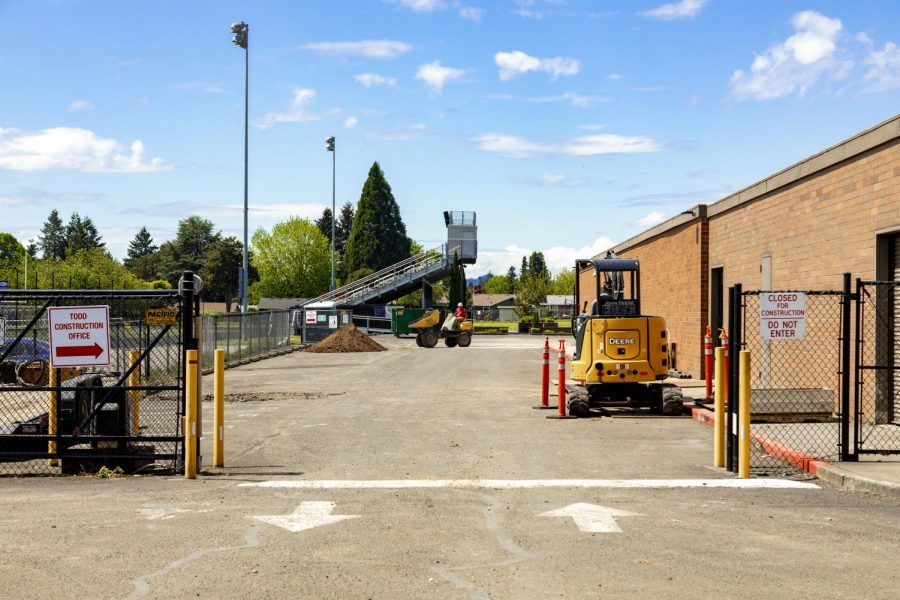 Construction vehicles in the side parking lot between the football field and future Saalfeld Athletic Center.