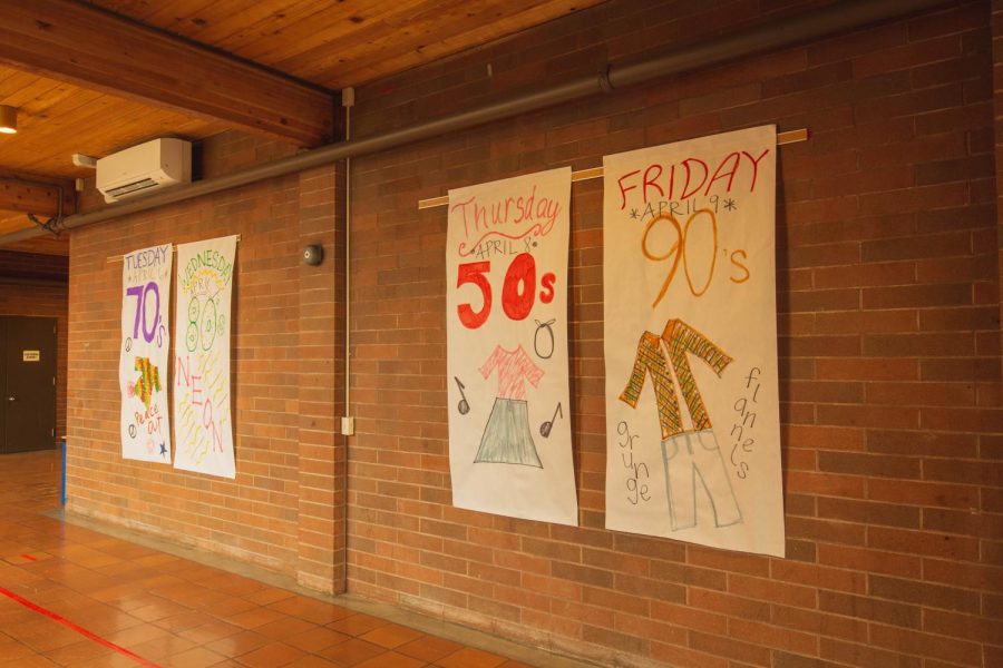 Made by the student council, posters in La Salles halls display examples of how students could dress on each day of decades week.