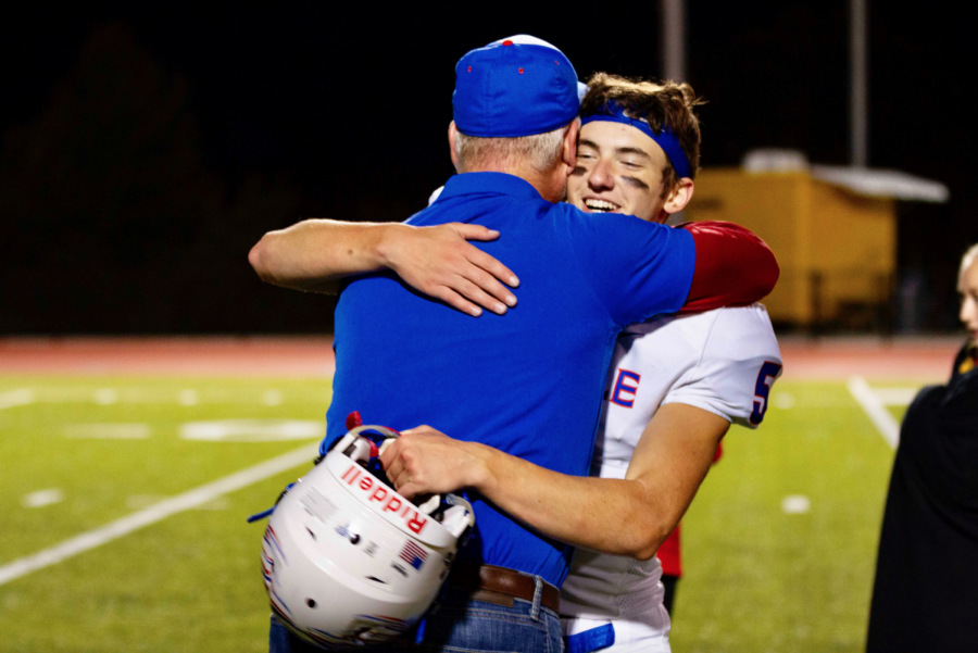 Rosumny embraces Mr. Tom McLaughlin, who is chaplain and waterboy for the football team, in a game from his junior year season. 