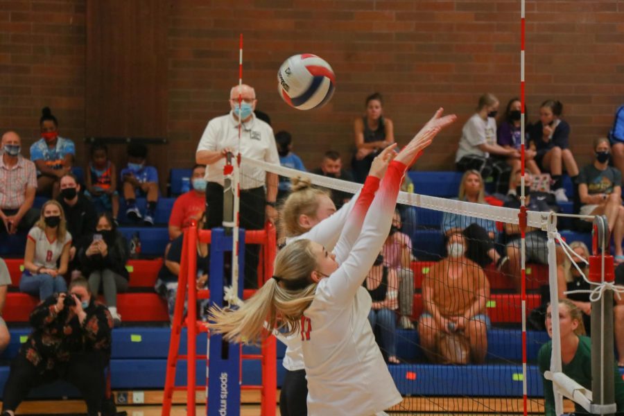 Lily Scherler and Olivia Maulding jump to block a spike. 