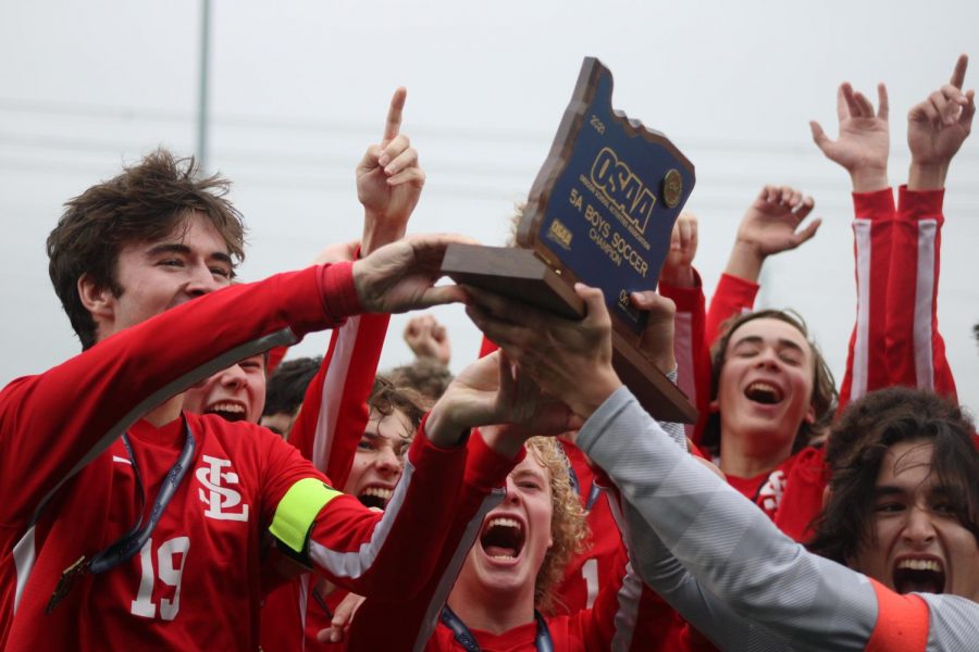 The boys soccer team erupted into cheers upon receiving their trophy.