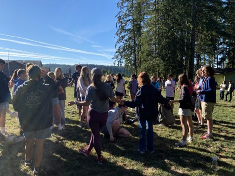 9th graders, student leaders, and teachers play games in the field while waiting for the activity rotations to begin. 