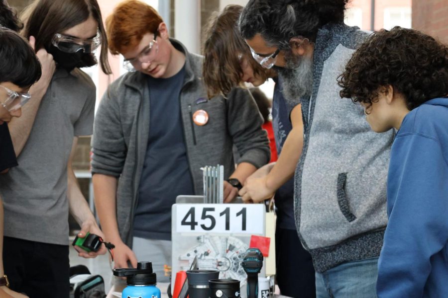 The La Salle team comes together to examine their robot after a match.