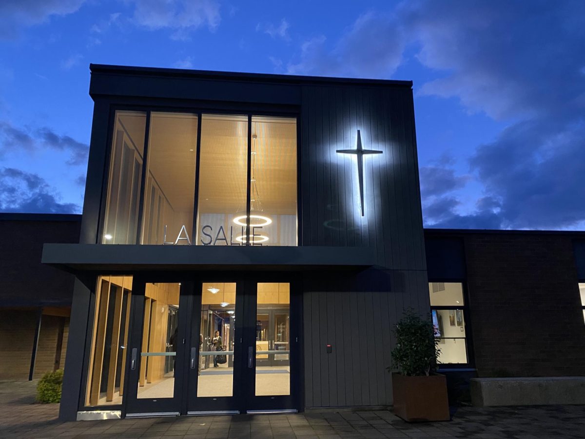The front entrance of the school is illuminated by the cross at sunset. 
