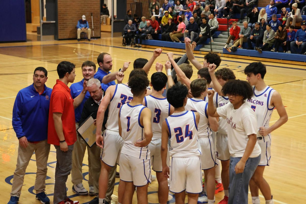 The boys basketball team finishing a time-out during their senior night game against Centennial High School. 
