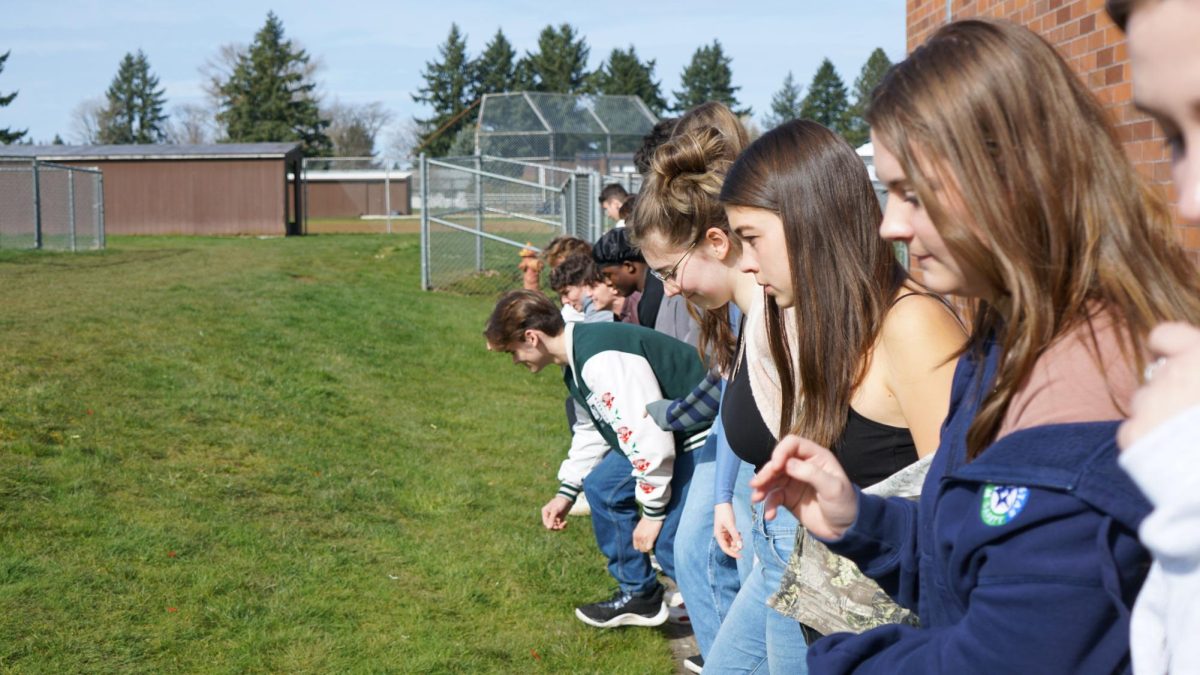 Students in Ms. Amanda Schiebers Biology class take advantage of the brighter weather by doing an activity outside.