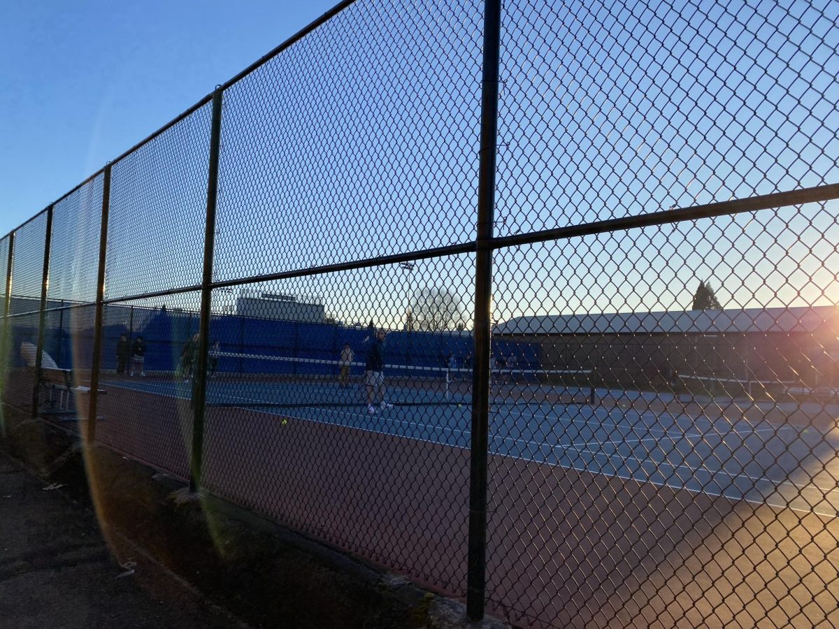 The boys tennis team during practice as the sun sets.