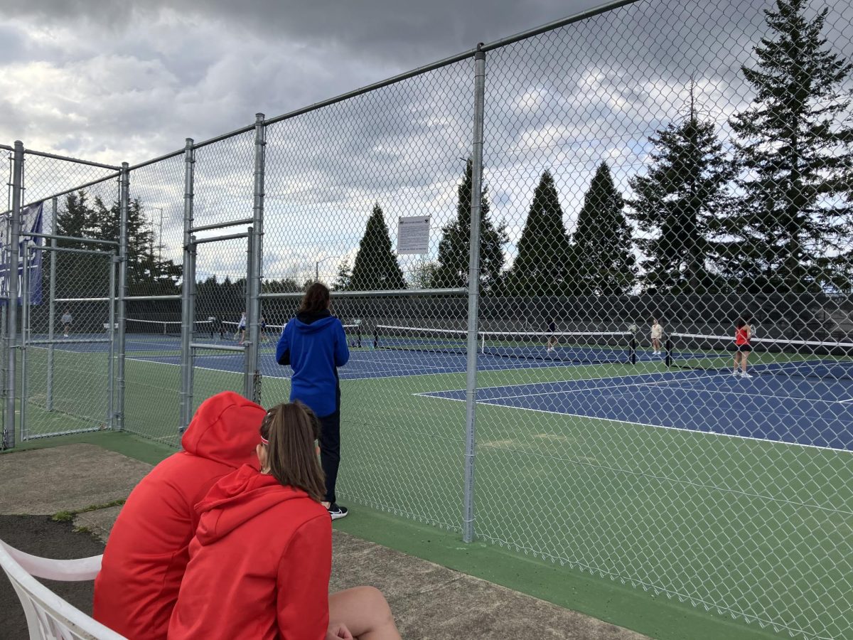 Tennis players watch a match at Valley Catholic.