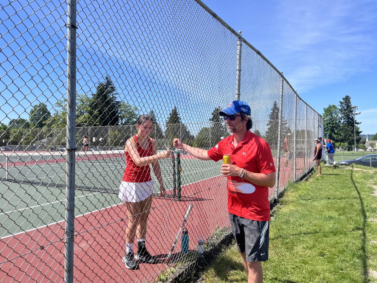 Junior Kennedy Harris fist-bumps her tennis coach, Mr. David Lane, mid-match at the second day of the Girls’ Tennis Districts tournament.