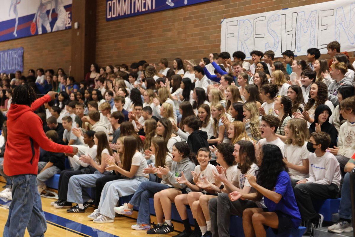 The freshmen, wearing their class color white, cheer for participants of the games. 