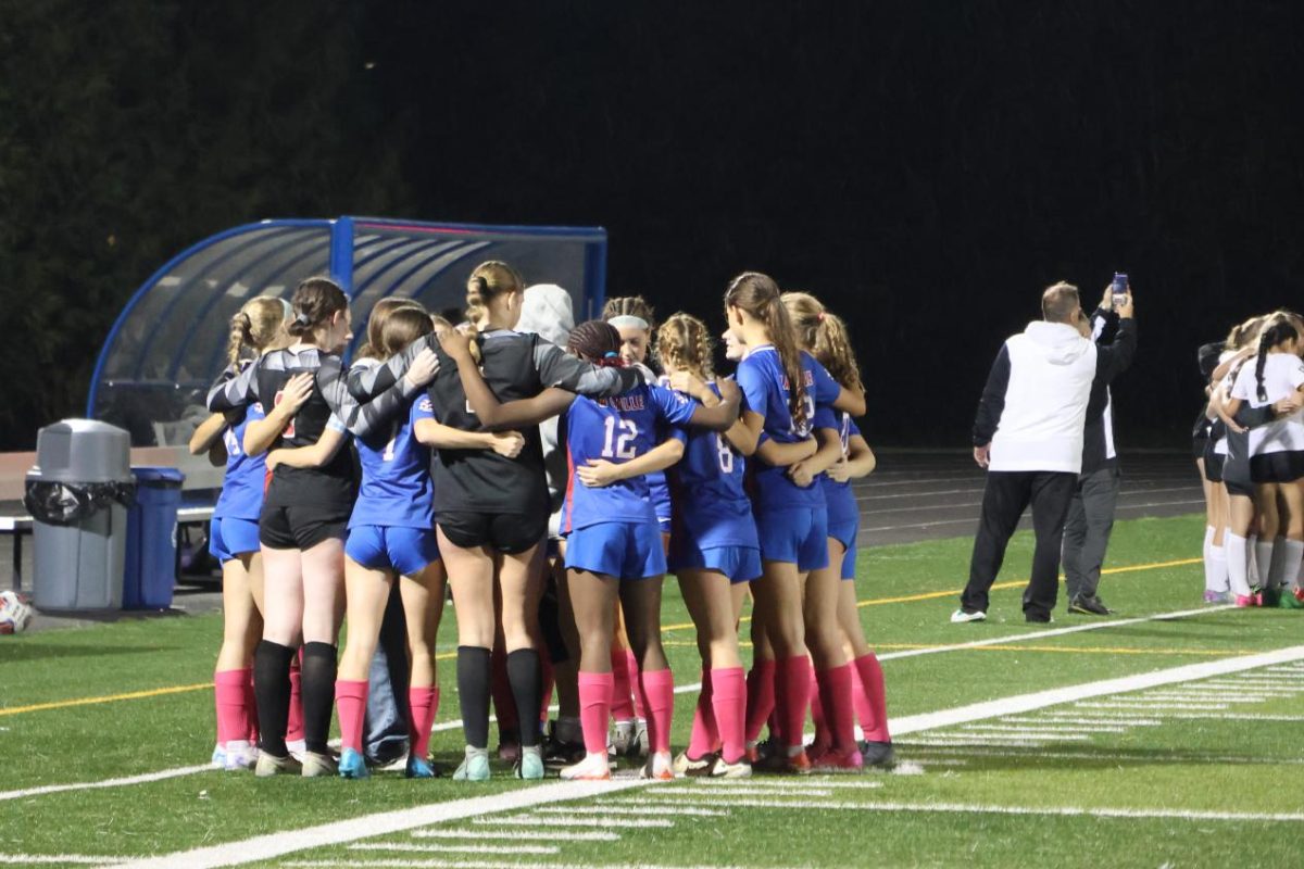 The varsity girls soccer team comes together at halftime against Putnam High School.
