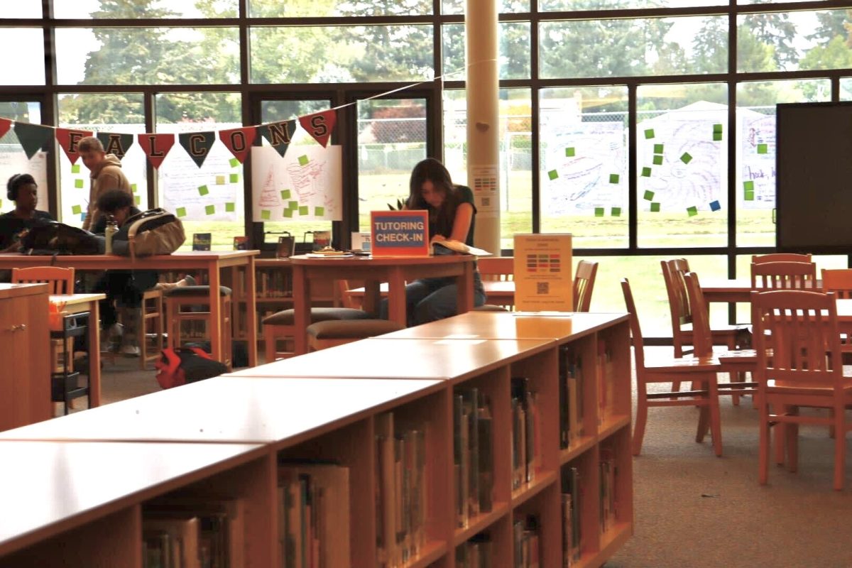 A lead peer tutor waits for students to check into peer tutoring in the library after school on Tuesday, Oct. 15.