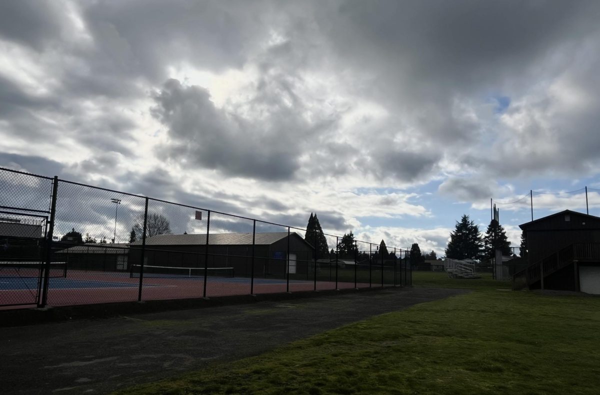 A view of the tennis court under the cloudy sky.